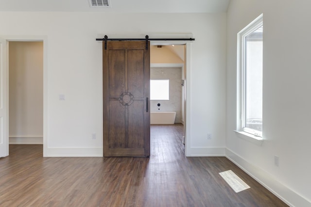 7710 46th St, Lubbock, TX 79407 - unfurnished room featuring dark wood-style floors and a barn door