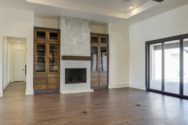 7710 46th St, Lubbock, TX 79407 - unfurnished living room featuring dark wood finished floors, a fireplace, recessed lighting, and a tray ceiling