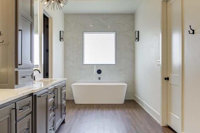 7710 46th St, Lubbock, TX 79407 - bathroom featuring a freestanding bath, vanity, and wood finished floors