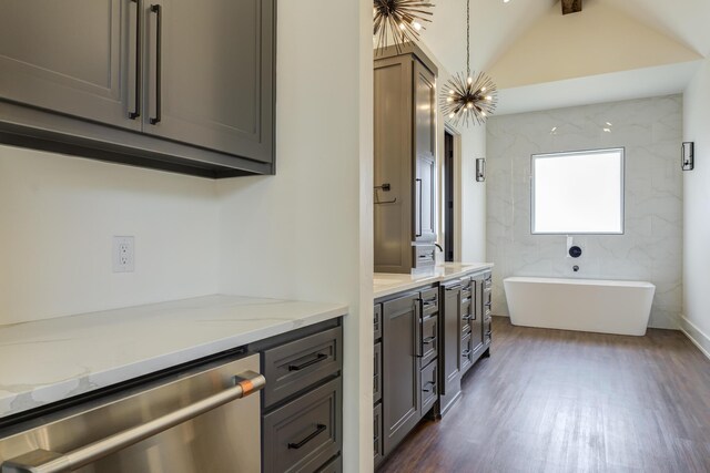 7710 46th St, Lubbock, TX 79407 - kitchen with stainless steel dishwasher, dark wood-style flooring, light stone countertops, lofted ceiling, and gray cabinetry