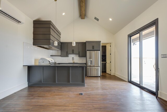 7710 46th St, Lubbock, TX 79407 - kitchen with stainless steel fridge, a wall unit AC, beam ceiling, a peninsula, and healthy amount of natural light