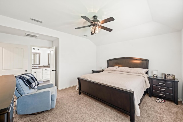 bedroom with light colored carpet, vaulted ceiling, a ceiling fan, and ensuite bathroom