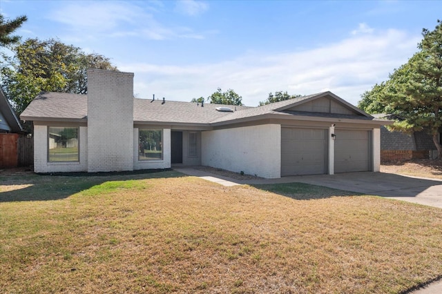 single story home with driveway, a chimney, a front lawn, a garage, and brick siding