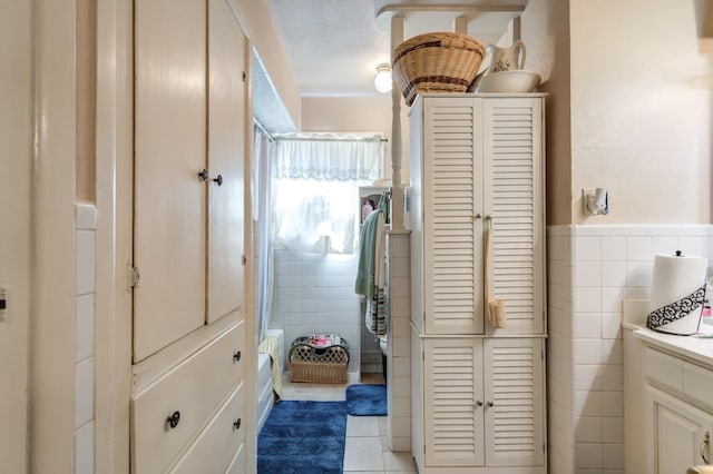 bathroom with tile walls, vanity, tile patterned floors, and toilet