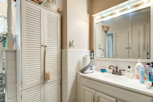 bathroom featuring vanity and tile walls