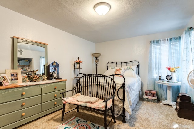 bedroom featuring light colored carpet and a textured ceiling