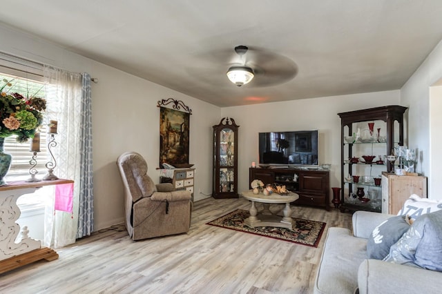 living room featuring light hardwood / wood-style floors and ceiling fan