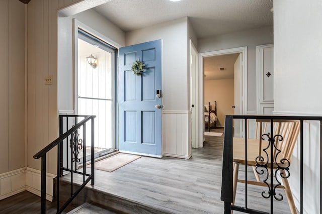 foyer entrance with hardwood / wood-style flooring and a textured ceiling