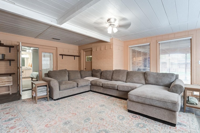 living room featuring ceiling fan, beam ceiling, and hardwood / wood-style floors