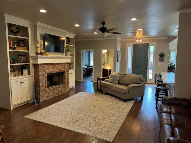 living room with dark hardwood / wood-style flooring, crown molding, and built in shelves