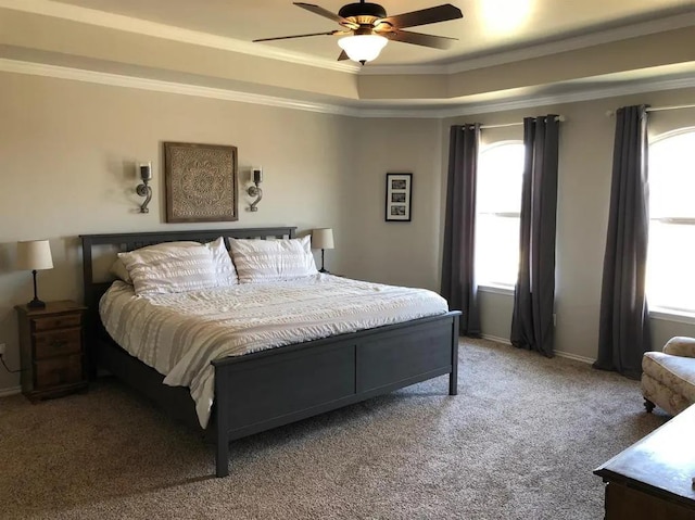 bedroom with a tray ceiling, crown molding, ceiling fan, and carpet