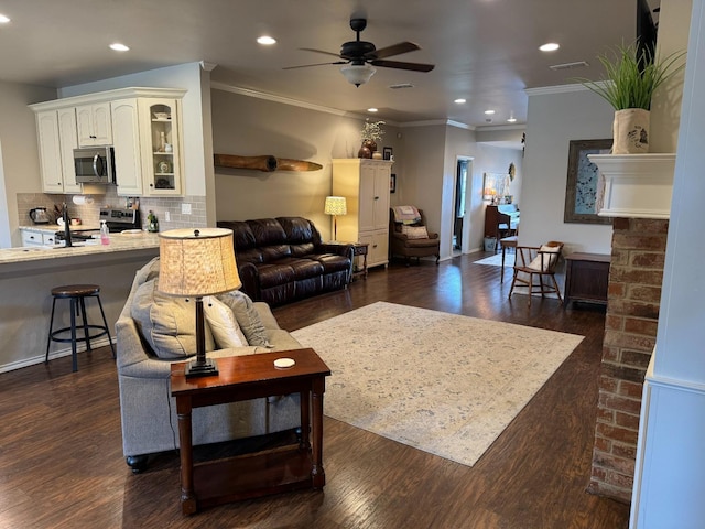 living room with ceiling fan, ornamental molding, and dark hardwood / wood-style floors