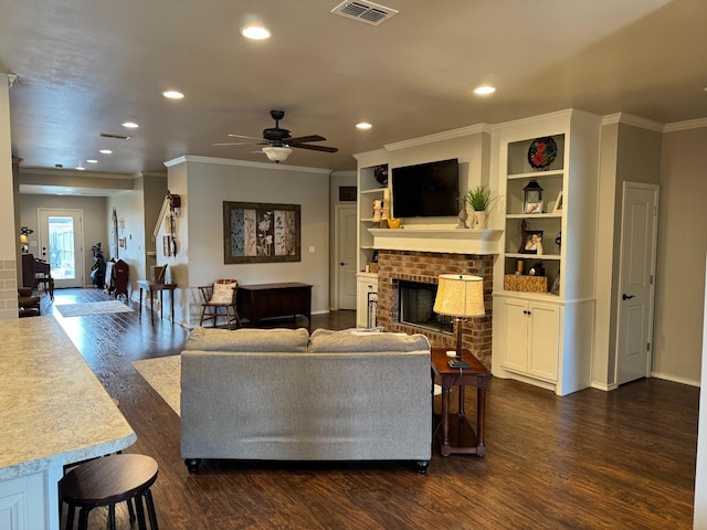 living room with crown molding, a fireplace, and dark hardwood / wood-style flooring