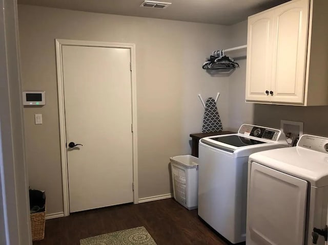 washroom featuring cabinets, washing machine and dryer, and dark hardwood / wood-style floors