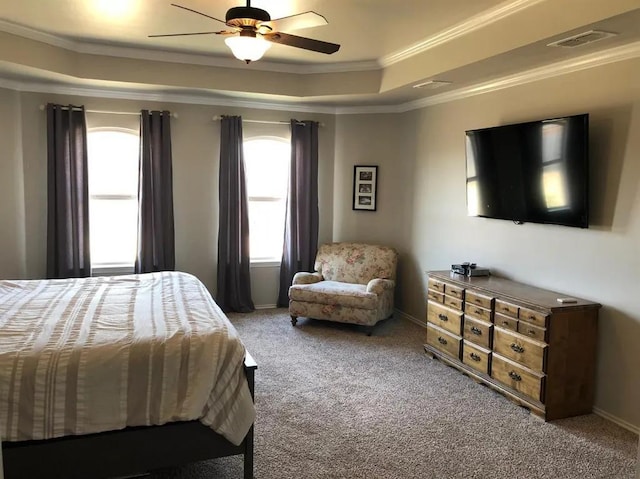 bedroom with a tray ceiling, ornamental molding, ceiling fan, and carpet