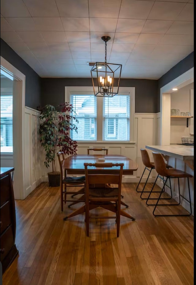 dining area featuring wood-type flooring and a notable chandelier