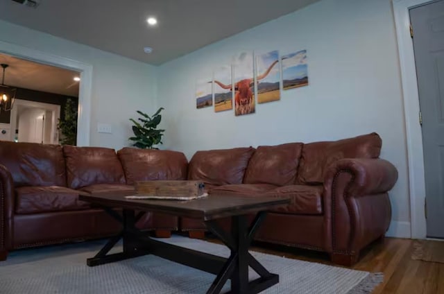 living room featuring hardwood / wood-style flooring and an inviting chandelier