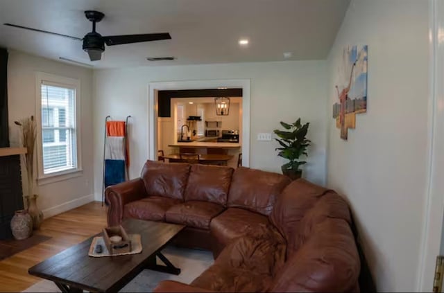 living room featuring ceiling fan and light hardwood / wood-style flooring