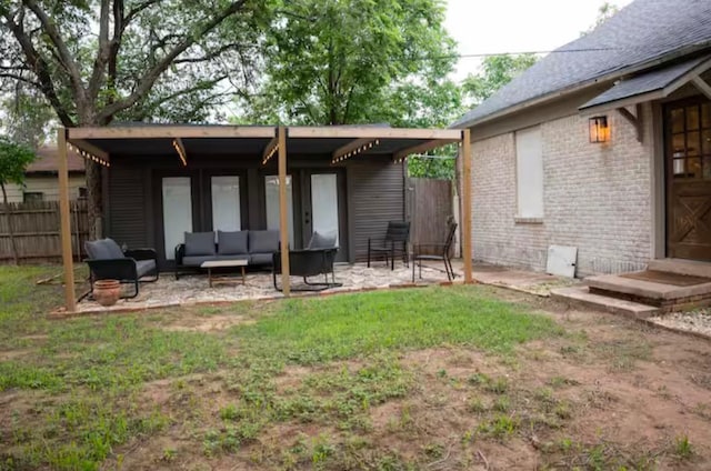 back of property with outdoor lounge area, a lawn, and a patio area