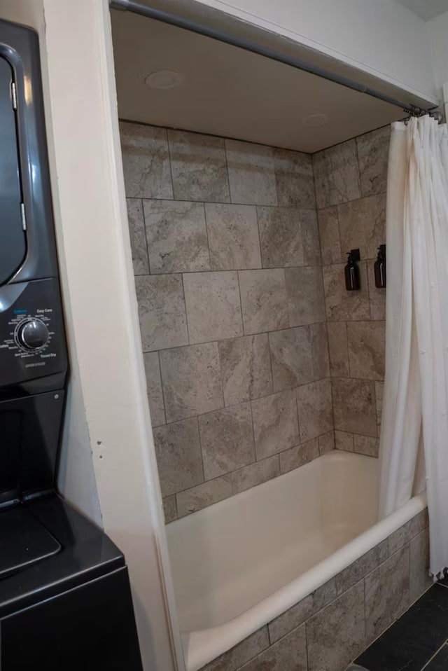 bathroom with stacked washer / dryer and shower / tub combo with curtain