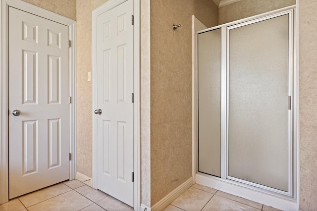 bathroom with an enclosed shower and tile patterned flooring