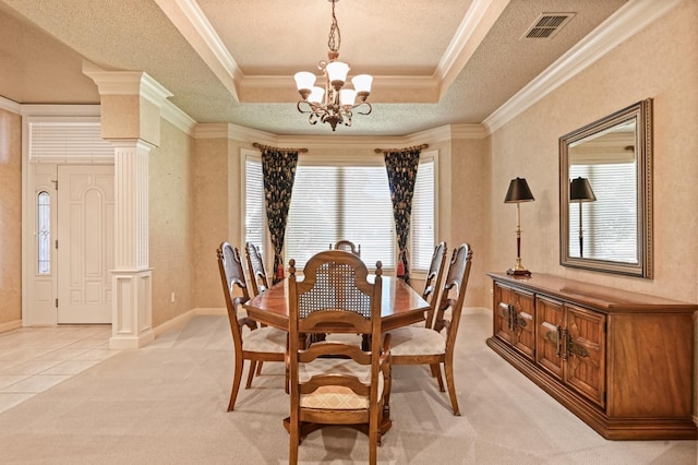 dining room featuring crown molding, decorative columns, a raised ceiling, and a chandelier