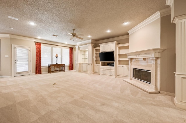 unfurnished living room featuring crown molding, a textured ceiling, ceiling fan, light colored carpet, and a high end fireplace