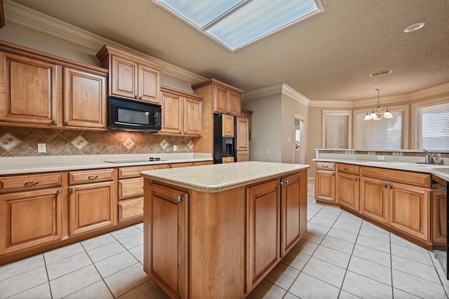 kitchen featuring pendant lighting, backsplash, ornamental molding, black appliances, and light tile patterned flooring