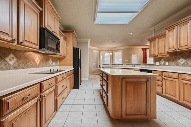 kitchen featuring light tile patterned floors, ornamental molding, black appliances, and a textured ceiling