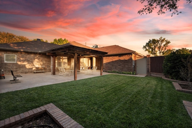 yard at dusk featuring a patio area