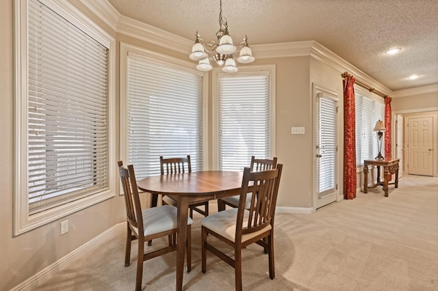 dining room featuring light carpet, plenty of natural light, ornamental molding, and a textured ceiling