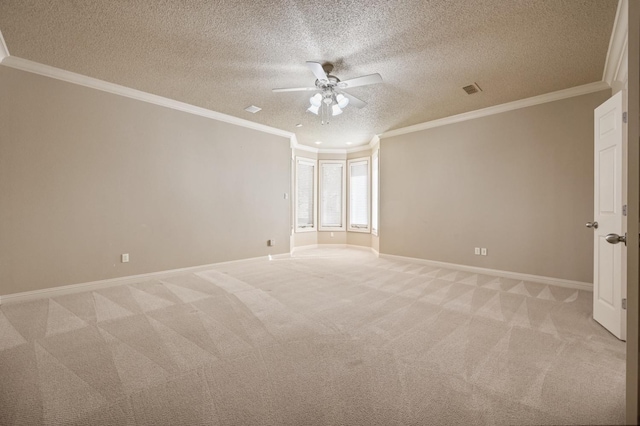 carpeted empty room with ceiling fan, ornamental molding, and a textured ceiling