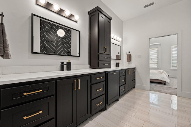 full bath with double vanity, visible vents, a sink, ensuite bath, and baseboards