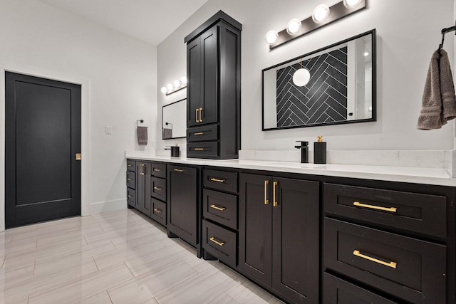 bathroom with baseboards, a sink, and double vanity