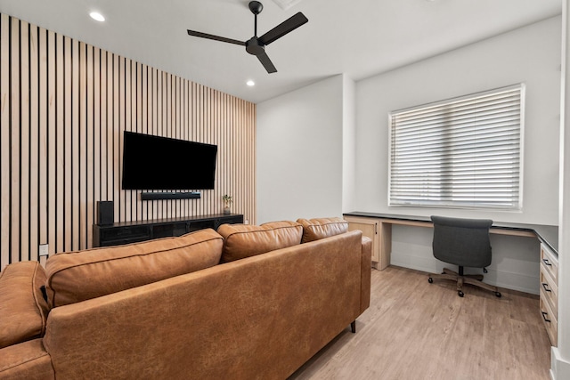living room featuring built in desk, ceiling fan, light wood finished floors, baseboards, and recessed lighting