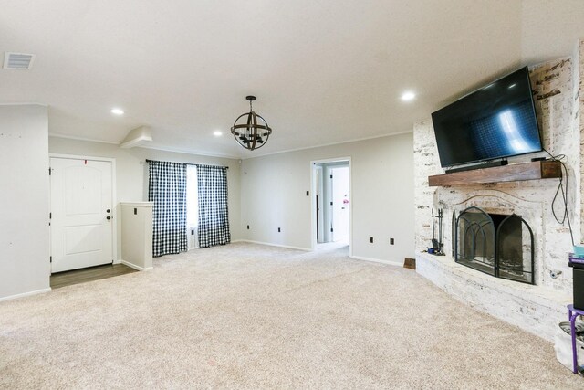 unfurnished living room featuring crown molding, a brick fireplace, light colored carpet, and a notable chandelier