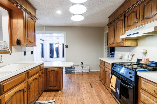 kitchen featuring sink, light hardwood / wood-style flooring, a textured ceiling, kitchen peninsula, and black range with electric stovetop