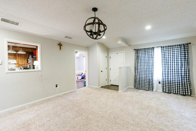 unfurnished bedroom with ensuite bathroom, carpet, stainless steel fridge with ice dispenser, a textured ceiling, and an inviting chandelier