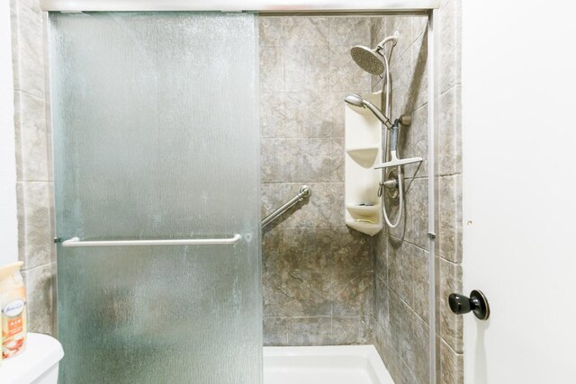 bathroom with an enclosed shower and toilet