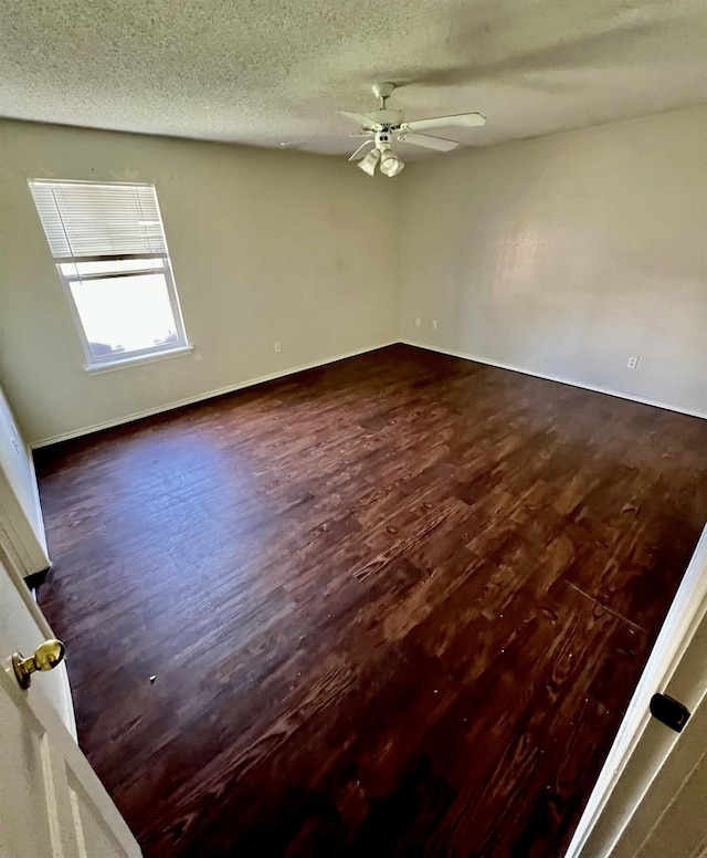 unfurnished room with ceiling fan, dark hardwood / wood-style floors, and a textured ceiling