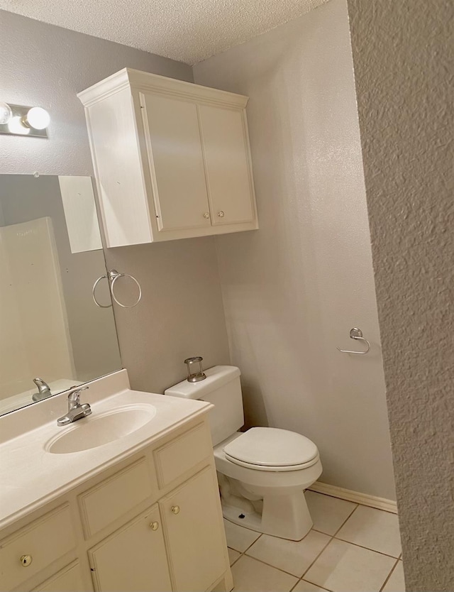 bathroom with tile patterned flooring, vanity, a textured ceiling, and toilet