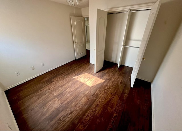 unfurnished bedroom with dark wood-type flooring