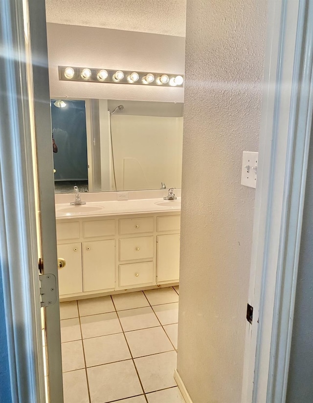 bathroom with vanity, tile patterned floors, and a textured ceiling