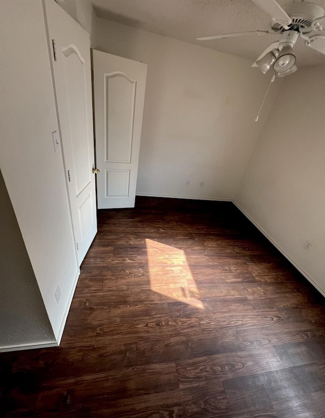 empty room with dark hardwood / wood-style floors and ceiling fan