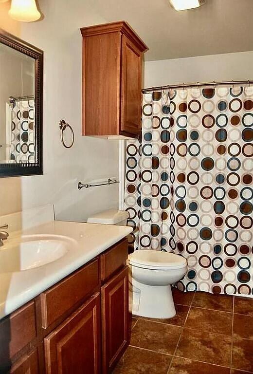 bathroom featuring tile patterned flooring, vanity, and toilet