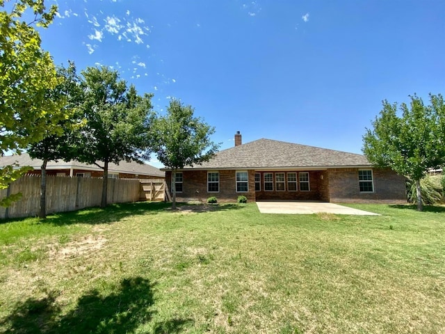 rear view of house with a yard and a patio