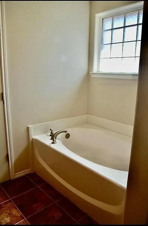 bathroom with a bathing tub and tile patterned floors