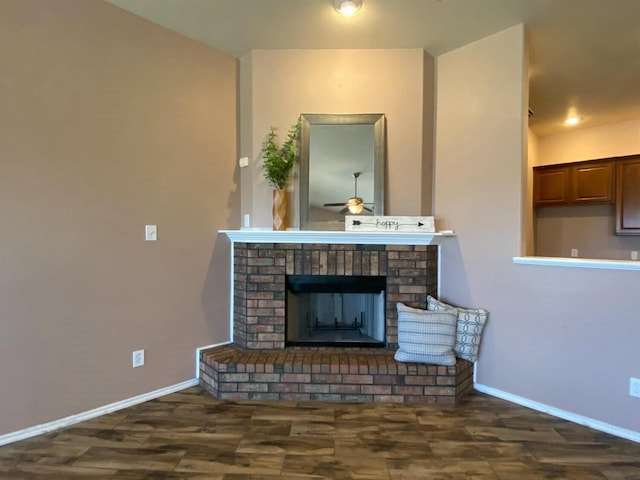 living room with a brick fireplace, dark hardwood / wood-style floors, and ceiling fan