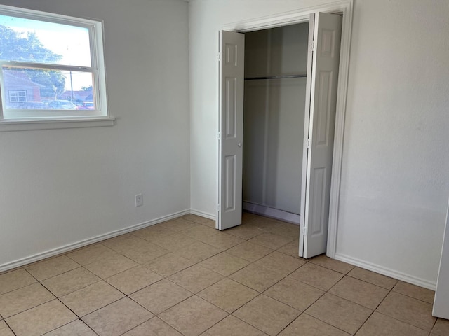 unfurnished bedroom with light tile patterned floors and a closet