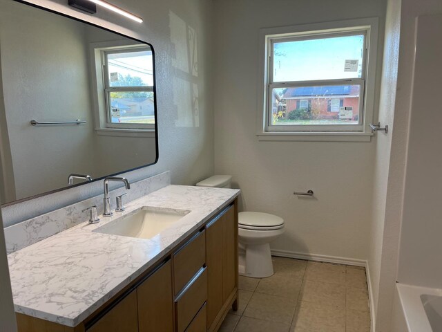 bathroom with tile patterned flooring, vanity, and toilet